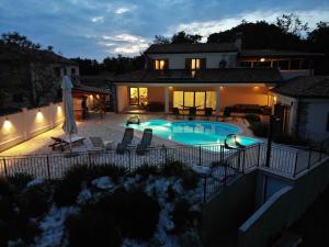 una casa con piscina por la noche en Villa Arton heated swimming-pool, en Žminj