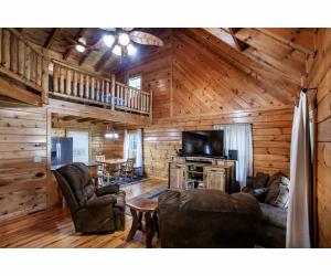 uma sala de estar com sofás e uma mesa numa cabina em Mamaw's Place - Creek, Large Yard, Great Location! em Sevierville
