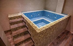 uma grande banheira com piso em madeira em Hotel Park Shtip em Stip