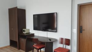 a room with a table and a tv on a wall at Apartamenty Śląsk in Zabrze