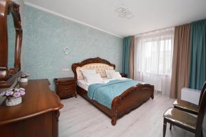 a bedroom with a bed and a dresser and a desk at De`Lore Park Hotel Domodedovo in Domodedovo