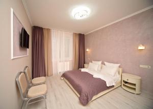 a hotel room with a bed and a chair at De`Lore Park Hotel Domodedovo in Domodedovo