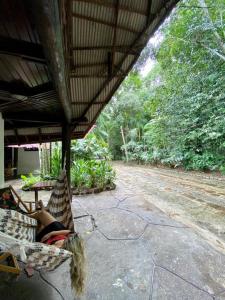 Eine Frau, die in einer Hängematte auf einer Veranda liegt. in der Unterkunft ReservAmazon Forest Hotel in Belém