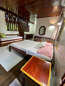 una camera con due letti e un tavolo in legno di ReservAmazon Forest Hotel a Belém