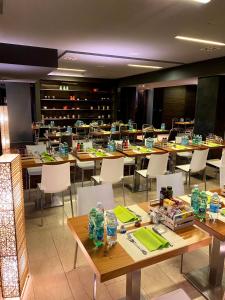ein Esszimmer mit Holztischen und weißen Stühlen in der Unterkunft Bes Hotel Cremona Soncino in Soncino