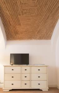 a dresser with a television on top of it at Casa do Sembrano in Beja