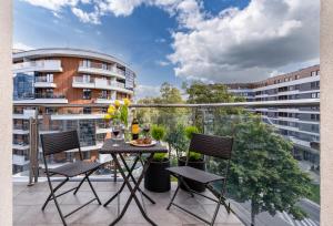 a balcony with a table and chairs and a building at Apartament Mateo Inn in Kraków