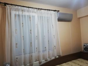 cortina blanca en un dormitorio con cama en ХОУМ ВТ, en Veliko Tŭrnovo