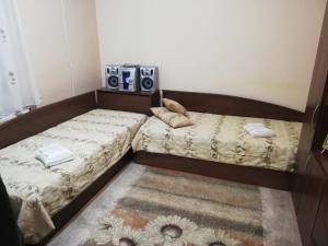 dos camas sentadas una al lado de la otra en una habitación en ХОУМ ВТ, en Veliko Tŭrnovo