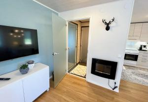 a living room with a flat screen tv on a wall at Cozy renovated house with a lot of parking space. in Haparanda