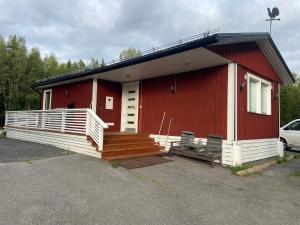 a red and white house with a porch and a car at Cozy renovated house with a lot of parking space. in Haparanda