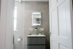 a bathroom with a sink and a mirror at Armada Cottages in Spanish Point +35 photos