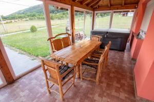 - une table et des chaises en bois sur une terrasse avec barbecue dans l'établissement Soul Vacation, à Korenica