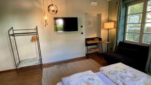 a living room with a bed and a tv at sleep & go -Meran easy staying in Merano