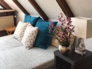 a bed with pillows and a vase of flowers on a table at Ferienhaus Chalet Dr. Winkler in Speichersdorf