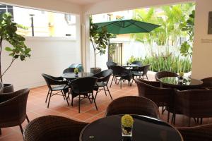 
a patio area with tables, chairs and umbrellas at Jinhold Service Apartment in Kuching
