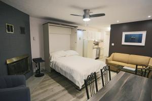 una camera da letto con un letto, un divano e un camino di Magog Waterfront Studio 106 a Magog-Orford