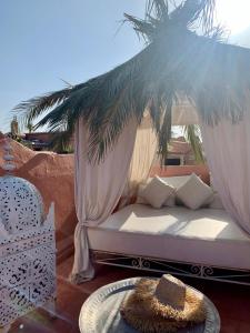 - un lit à baldaquin sur une terrasse avec une table dans l'établissement The Bohemian Jungle, à Marrakech