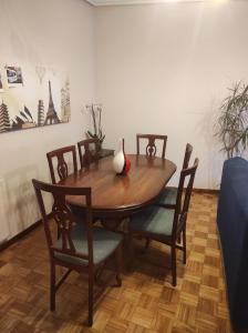 a dining room table with chairs and a vase on it at Piso luminoso y tranquilo en Ourense (O Couto) in Ourense