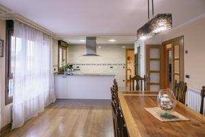 ein Esszimmer und eine Küche mit einem Holztisch und Stühlen in der Unterkunft Alojamiento Urabain in Allo