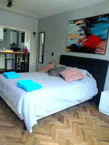 um quarto com uma cama branca e toalhas azuis em Estudio Rufina I Mendoza downtown em Mendoza
