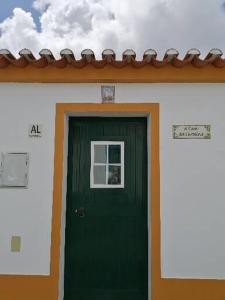 una puerta verde de una casa con ventana en A Casa da Carolina, en Mértola