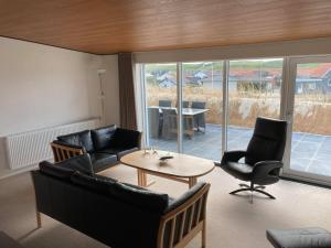 a living room with a couch and chairs and a table at Bakkebo in Hvide Sande