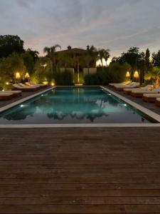 a swimming pool at night with chairs and lights at Santa Lucia Maccarese - Residenza Agricola in Maccarese
