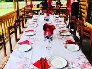 a long table with red napkins and glasses on it at Hotel Krojet e Rrogamit in Valbonë