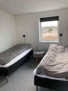 a bedroom with two beds and a window at Bakkebo in Hvide Sande