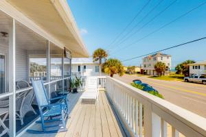 a porch with two blue chairs on a house at Moonlighting in Edisto Beach