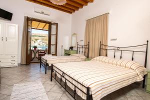 a bedroom with four beds in a room with a table at Stefanos Studios in Skala