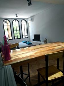 um quarto com uma mesa de madeira num quarto com janelas em Estudio Rufina I Mendoza downtown em Mendoza