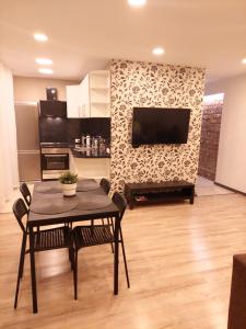 a living room with a table and a tv at M14 Apartment in Gulbene