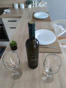 a bottle of wine sitting on a table with two wine glasses at Apartment Sve u 5 minuta in Zadar