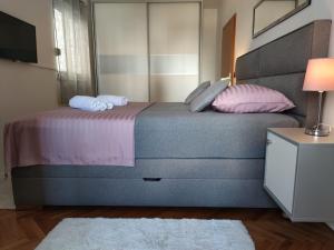 1 dormitorio con 1 cama grande con almohadas rosas en Apartment Sve u 5 minuta en Zadar