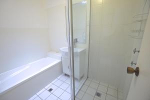 a bathroom with a shower and a toilet and a sink at Katoomba Townhouses in Katoomba