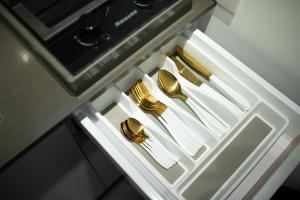 un cajón con utensilios, platos, tenedores de oro y cuchillos en Orel suite en Eilat