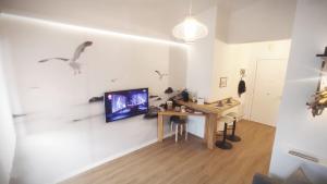 a room with a table and a tv on a wall at Greta a mare in Montesilvano