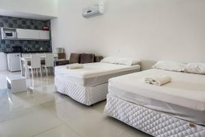 two beds in a room with a kitchen and a table at Terra Nostra Residence in Porto De Galinhas +21 photos