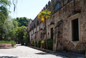 un edificio de ladrillo con una palmera al lado de una calle en Hotel Hacienda Vista Hermosa, en Tequesquitengo