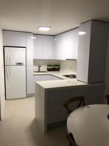 eine Küche mit weißen Schränken und einem weißen Kühlschrank in der Unterkunft Espectacular apartamento en San Andres Hansa Reef in San Andrés