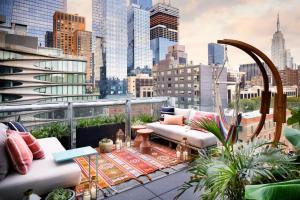 un balcón con sofás y plantas y un perfil urbano en Selina Chelsea en Nueva York