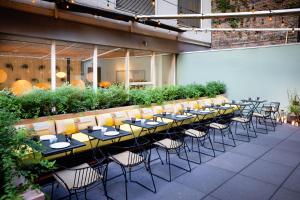 a row of tables with chairs in front of a building at Selina Chelsea in New York