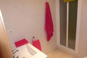 bagno con lavandino e asciugamani rossi sul muro di Casa Rural El Silvestrito a Valdejeña