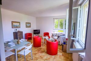 un soggiorno con sedie rosse e un tavolo di Chambres d'hôtes Avignon ad Avignone