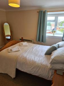 een slaapkamer met een groot wit bed en een raam bij Ramblers Rest in Kirriemuir