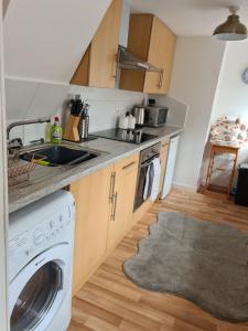 eine Küche mit einer Spüle und einer Waschmaschine in der Unterkunft Ramblers Rest in Kirriemuir