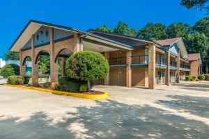 a large brick building with a tree in front of it at Americas Best Value Inn Stockbridge in Stockbridge