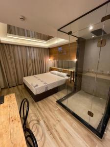 1 dormitorio con 1 cama y pared de cristal en Hotel Cantareira (Adults Only), en São Paulo